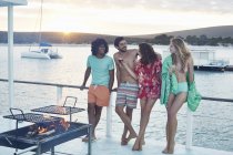 Giovani amici adulti appendere fuori e bere sulla casa galleggiante estate — Foto stock