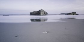 Ruinas en el océano tranquilo en marea baja, Vigsoe, Dinamarca - foto de stock