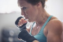 Nahaufnahme entschlossene, harte Boxerin Schattenboxen — Stockfoto