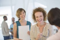 Büroangestellte plaudern und lachen während Besprechung — Stockfoto