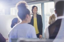 Smiling businesswoman leading conference presentation — Stock Photo