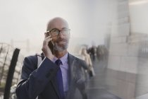 Homme d'affaires parlant sur téléphone portable dans la rue urbaine — Photo de stock