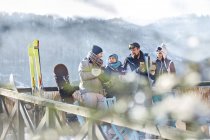 Друзья лыжники разговаривают и пьют коктейли на солнечном балконе apres-ski — стоковое фото