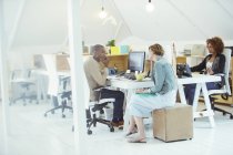 Büroangestellte unterhalten sich am Schreibtisch im modernen Büro — Stockfoto