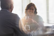 Lächelndes älteres Paar trinkt Wein, speist am Restauranttisch — Stockfoto