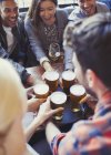 Бармен подает пиво на подносе друзьям в баре — стоковое фото
