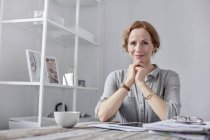 Portrait femme d'affaires souriante et confiante utilisant une tablette numérique et buvant du thé au bureau — Photo de stock