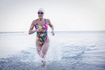 Female active swimmer running at ocean outdoors — Stock Photo
