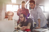 Four young designers working at laptop — Stock Photo