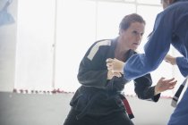 Entschlossene, toughe Frau übt Judo im Fitnessstudio — Stockfoto