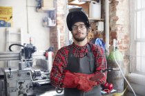 Портрет уверенный сварщик с сварочной горелкой в мастерской — стоковое фото