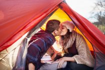 Jeune couple camping, embrasser à l'intérieur tente — Photo de stock
