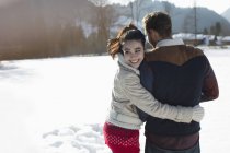 Счастливая пара, идущая по снегу — стоковое фото