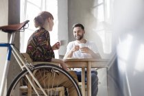 Couple talking and drinking coffee at table — Stock Photo