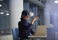 Femme d'affaires utilisant le simulateur de réalité virtuelle à l'ordinateur portable dans le bureau — Photo de stock