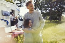Affettuoso padre e figlia che si abbracciano al di fuori del camper soleggiato — Foto stock
