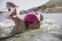 Determinato nuotatore femmina in mare aperto nuotare nell'oceano soleggiato — Foto stock