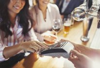 Жінка платить барменом за допомогою кредитної картки в барі — стокове фото