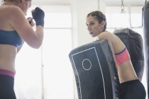 Women practicing kickboxing with padding in gym — Stock Photo