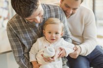 Portrait cute baby son with male gay parents — Stock Photo