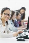 Portrait smiling girl student using computer in computer lab — Stock Photo