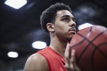 Ritratto serio, focalizzato giovane giocatore di basket maschile con in mano pallacanestro — Foto stock