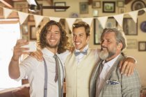 Best man, bridegroom and father taking selfie in domestic room — Stock Photo