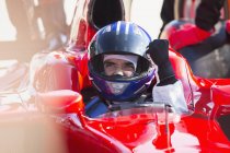 Formula one race car driver in helmet gesturing, celebrating victory — Stock Photo