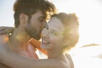 Retrato de una joven pareja sonriente a la luz del sol - foto de stock