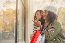 Young women friends window shopping at storefront — Stock Photo