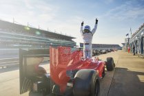 Formula one race car driver cheering on sports track, celebrating victory — Stock Photo