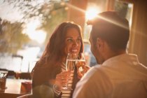 Jovem casal afetuoso brindar taças de champanhe no restaurante — Fotografia de Stock