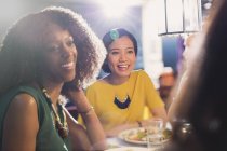 Women friends talking and dining at restaurant table — Stock Photo