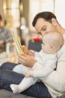 Отец читает книжку миленькому сыну — стоковое фото