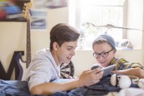 Dois adolescentes compartilhando tablet digital no quarto — Fotografia de Stock