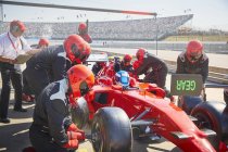 Tripulación de hoyos reemplazando neumáticos en Fórmula 1 en sesión de práctica de pit lane - foto de stock