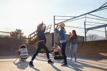 Друзья дают пять в солнечном скейт-парке — стоковое фото