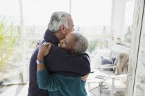 Affettuosa coppia anziana che abbraccia sul portico del sole — Foto stock