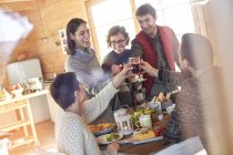 Amici brindare bicchieri di vino a tavola cabina — Foto stock