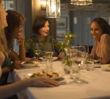 Жінки друзі їдять і розмовляють за столом ресторану — стокове фото