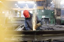 Сварщик с помощью сварочной горелки на сталелитейном заводе — стоковое фото