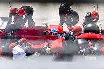 Manager mit Stoppuhr: Boxencrew tauscht Reifen an Formel-1-Rennwagen in der Boxengasse aus — Stockfoto