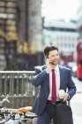 Бизнесмен разговаривает по мобильному телефону на тротуаре города — стоковое фото
