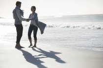 Jeune couple tenant la main sur la plage — Photo de stock
