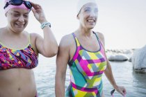 Nuotatrici attive femminili in piedi presso l'acqua dell'oceano all'aperto — Foto stock