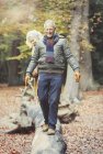Coppia anziana che cammina sul tronco nei boschi autunnali — Foto stock