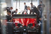 Boxencrew bereitet Formel-1-Rennwagen in Werkstatt vor — Stockfoto