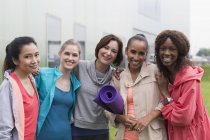 Portrait smiling women friends with yoga mat — Stock Photo