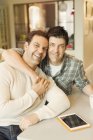 Портрет усміхнений, ласкавий чоловічий гей-пара з цифровим планшетом обіймає — стокове фото