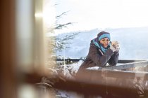 Portrait smiling female skier drinking hot cocoa on sunny cabin balcony — Stock Photo